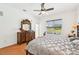 Inviting main bedroom with hardwood floors, decorative dresser, and pool view through the window at 21019 Lonesome Acre Rd, Wimauma, FL 33598