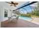 Relaxing covered patio with a sparkling pool, lush landscaping, and ample seating at 21019 Lonesome Acre Rd, Wimauma, FL 33598