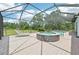 A sparkling pool and separate hot tub are surrounded by brick pavers in a screened-in enclosure at 21019 Lonesome Acre Rd, Wimauma, FL 33598