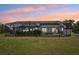 Back of the home featuring screened in patio with view of backyard at dusk at 21019 Lonesome Acre Rd, Wimauma, FL 33598