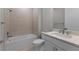 Modern bathroom with white vanity, tub, shower, and neutral tile accents at 2541 Charter Oak Dr, North Port, FL 34289
