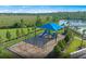This is a covered playground with swings, a slide, and lush landscaping near a lake at 2541 Charter Oak Dr, North Port, FL 34289