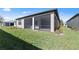 Exterior view of the home's rear featuring a screened patio and green lawn at 2541 Charter Oak Dr, North Port, FL 34289