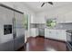 Bright kitchen with stainless steel appliances, white cabinetry, and a window above the sink overlooking the yard at 2810 N Jefferson St, Tampa, FL 33602