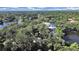 Spacious home surrounded by lush trees is near a lake in an aerial view at 315 Wooten Rd, Lutz, FL 33548