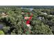 Lush greenery surrounds a home as seen from the air near a placid lake at 315 Wooten Rd, Lutz, FL 33548