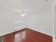 Bright bedroom features hardwood floors, a ceiling fan, and natural light from the window at 315 Wooten Rd, Lutz, FL 33548