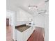Bright kitchen featuring white cabinetry, dark granite countertops, and wood flooring at 315 Wooten Rd, Lutz, FL 33548