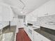 Bright kitchen featuring white cabinets, stainless sink, and stone countertops at 315 Wooten Rd, Lutz, FL 33548