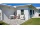 Back patio with chair, table, and manicured backyard at 3436 100Th N Ave, Pinellas Park, FL 33782