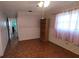 Cozy bedroom featuring parquet floors, a large window, and a view to the hallway at 3436 100Th N Ave, Pinellas Park, FL 33782