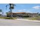 A welcoming clubhouse with a red tile roof in a landscaped setting with palm trees, offering community activities at 3436 100Th N Ave, Pinellas Park, FL 33782