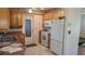 Efficient kitchen layout with wooden cabinets, white appliances, and a convenient exterior door at 3436 100Th N Ave, Pinellas Park, FL 33782