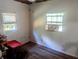 Bedroom features updated laminate flooring, two windows, and ceiling fan at 37654 Eiland Blvd, Zephyrhills, FL 33542