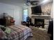 Bedroom with stacked boxes next to bed and a fireplace with large flatscreen TV at 37654 Eiland Blvd, Zephyrhills, FL 33542