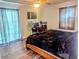 Comfortable bedroom features a ceiling fan, TV, a workspace, and wood-look laminate flooring at 37654 Eiland Blvd, Zephyrhills, FL 33542