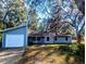 Charming single-story home featuring attached garage and a neatly maintained front yard with mature trees at 37654 Eiland Blvd, Zephyrhills, FL 33542