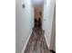 Hallway with updated floors leading to bedrooms and living areas, neutral paint and lighting at 37654 Eiland Blvd, Zephyrhills, FL 33542