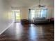 Open living room with wood flooring, ceiling fan, and plenty of natural light from the windows at 37654 Eiland Blvd, Zephyrhills, FL 33542