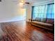 Bright living room with wood flooring, ceiling fan, and lots of natural light from the large window at 37654 Eiland Blvd, Zephyrhills, FL 33542