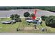 Aerial view of home with fenced yard, playground, detached garage and farmland in the background at 3908 N Forbes Rd, Plant City, FL 33565