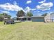 View of the backyard featuring a playhouse, trampoline, screened porch, and storage shed at 3908 N Forbes Rd, Plant City, FL 33565