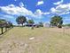 Spacious fenced backyard with large trees, play equipment, and ample space for outdoor activities at 3908 N Forbes Rd, Plant City, FL 33565