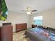 Cozy bedroom featuring wood floors, dresser, and a ceiling fan at 3908 N Forbes Rd, Plant City, FL 33565