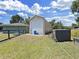 View of a detached one-car garage adjacent to the house in a well-maintained backyard at 3908 N Forbes Rd, Plant City, FL 33565