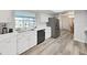 Bright kitchen with white cabinets, modern appliances, and durable vinyl flooring at 3908 N Forbes Rd, Plant City, FL 33565