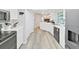 Bright kitchen features modern appliances, white cabinetry, and stylish wood-look flooring at 3908 N Forbes Rd, Plant City, FL 33565