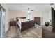 Spacious main bedroom featuring wood-look floors, ceiling fan, and access to a sliding glass door at 3908 N Forbes Rd, Plant City, FL 33565
