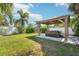 A backyard features a well-maintained lawn, lush palm trees, a wooden pergola, and a hot tub at 4091 Cherry Ne St, St Petersburg, FL 33703