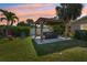 A backyard has an inviting gazebo covering a hot tub, complemented by lush greenery and colorful chairs at 4091 Cherry Ne St, St Petersburg, FL 33703