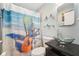 Updated bathroom with a unique vessel sink and an artistic shower curtain creates a beachy vibe at 4091 Cherry Ne St, St Petersburg, FL 33703