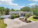 Well-maintained single-story home featuring a brick driveway, lush landscaping, and solar panels on the roof at 4091 Cherry Ne St, St Petersburg, FL 33703