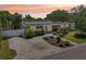 Inviting home exterior boasts solar panels, neatly manicured landscaping, and a paved driveway at sunset at 4091 Cherry Ne St, St Petersburg, FL 33703