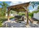 A hot tub sits under a wooden pergola with a concrete base and surrounded by green landscaping at 4091 Cherry Ne St, St Petersburg, FL 33703