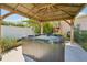 A close up of a filled and heated hot tub underneath a wooden pergola at 4091 Cherry Ne St, St Petersburg, FL 33703
