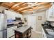 Bright kitchen with white cabinets, stainless steel appliances, and wooden beam ceiling at 4091 Cherry Ne St, St Petersburg, FL 33703