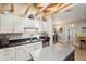 Bright kitchen with white cabinets, stainless steel appliances, and wooden beam ceiling looking into another room at 4091 Cherry Ne St, St Petersburg, FL 33703