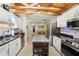 Bright kitchen with white cabinets, stainless steel appliances, and wooden beam ceiling looking into dining area at 4091 Cherry Ne St, St Petersburg, FL 33703