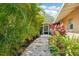 Charming pathway with stone and lush landscaping, leading to the screened patio entrance at 4091 Cherry Ne St, St Petersburg, FL 33703