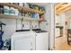 Bright laundry room with washer, dryer, and shelving, conveniently located near the kitchen at 4091 Cherry Ne St, St Petersburg, FL 33703