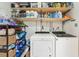 Well-stocked laundry room with washer, dryer, and convenient shelving for storage at 4091 Cherry Ne St, St Petersburg, FL 33703