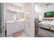 Well-lit bathroom showcasing a vanity with storage, modern fixtures, and views of the adjacent bedroom at 4212 Fairway Cir, Tampa, FL 33618