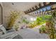 Cozy patio area with a pergola and comfortable seating surrounded by lush plants and landscaping at 4212 Fairway Cir, Tampa, FL 33618