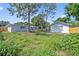 Spacious backyard with lush greenery, complemented by the home's exterior, offering a serene outdoor setting at 4719 Ohio Ave, Tampa, FL 33616