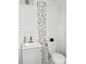 This bathroom features a white toilet and sink, with stylish gray and white square tile accents at 5118 Tennis Court Circle, Tampa, FL 33617