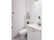 This well-lit bathroom features a white vanity, toilet, and a decorative plant on the counter at 5118 Tennis Court Circle, Tampa, FL 33617
